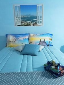 uma grande cama azul com 2 janelas num quarto em La Terrazza di Monica & Teresa em Portici