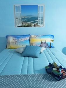 ein großes blaues Bett mit zwei Fenstern in einem Schlafzimmer in der Unterkunft La Terrazza di Monica & Teresa in Portici + 128 Fotos