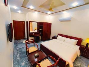 a hotel room with a bed and a desk and chair at Hotel Nova in Lahore