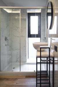 ein Bad mit einer Dusche, einem Waschbecken und einem Spiegel in der Unterkunft Arena Suites in Mar del Plata
