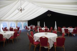 um quarto com mesas e cadeiras e uma tenda branca em Holmfield Arms by Greene King Inns em Wakefield