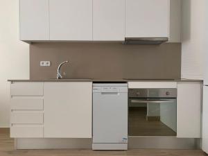 a kitchen with white cabinets and a sink and a stove at Ca La Rosalia Arbeca in Arbeca