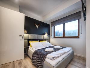 sypialnia z łóżkiem i oknem w obiekcie VisitZakopane - Apres SKI Apartment w Zakopanem