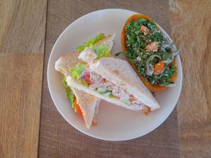 um prato branco com uma sanduíche e uma salada em Serenity Beach Cabanas em Tangalle