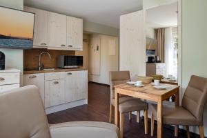 een keuken en eetkamer met een houten tafel en stoelen bij Insulaner Apartments in Helgoland