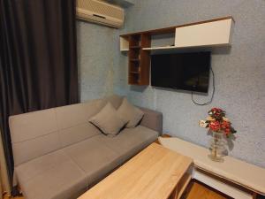 ein Wohnzimmer mit einem weißen Sofa und einem TV in der Unterkunft Ehli Keyif Otel in Istanbul