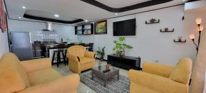 a living room with two couches and a kitchen at Panda House in Quepos