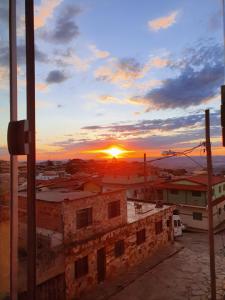 a sunset over a city with the sun setting at Suítes Nativa STL in São Thomé das Letras