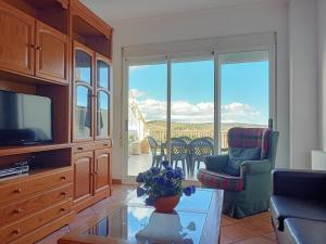 uma sala de estar com uma televisão, um sofá e uma mesa em Casa Esperanza em Alborache