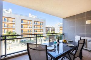 ein Esszimmer mit einem Tisch und Stühlen sowie einem Balkon in der Unterkunft Apartment Baixa Marina in Olhão