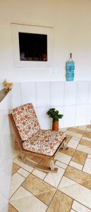 a chair sitting on a tiled floor in a room at Suítes Ninho da Águia Saquarema in Saquarema