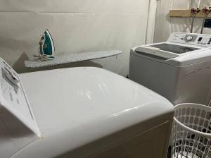 W łazience znajduje się pralka i umywalka. w obiekcie Cozy Modern and Lavish 3 Bedroom Basement Suite w mieście Winnipeg