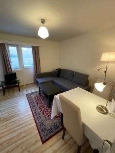 ein Wohnzimmer mit einem Sofa und einem Tisch in der Unterkunft Hofslund Apartments in Sogndal