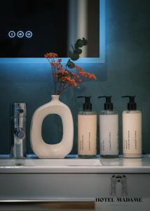 a counter with three bottles ofikiamine on a shelf at Hôtel Madame in Bordeaux