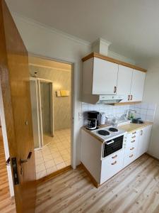 a kitchen with white cabinets and a stove at Hofslund Apartments in Sogndal