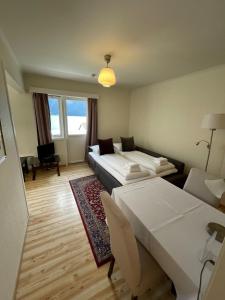 ein Hotelzimmer mit 2 Betten und einem Sofa in der Unterkunft Hofslund Apartments in Sogndal