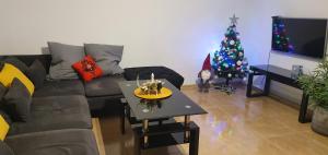 a living room with a christmas tree and a couch at Apartament przy Deptaku in Ustrzyki Dolne