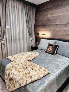 a bedroom with a bed with a blanket on it at Апартамент - Боровец Хотел ''Боровец Гардънс'' A 44 in Borovets