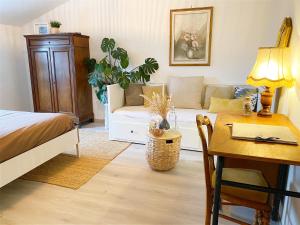 una camera con letto, tavolo e divano di L'Autre Rivière - Chambres d'hôtes a Ducey