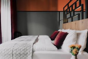 a bedroom with a white bed with red pillows at WELTWIEN Luxury Art Apartments in Vienna