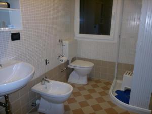 Łazienka z białą toaletą i umywalką w obiekcie Hotel Al Prato w mieście Tonezza del Cimone