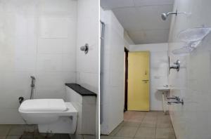 a bathroom with a toilet and a yellow door at I Care With Greenery Comforts in Devanahalli-Bangalore