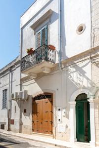 a white building with a wooden door and a balcony at WePuglia - Catarì in Polignano a Mare