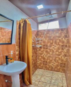 W łazience znajduje się prysznic i umywalka. w obiekcie Cabaña equipada w mieście Puerto Jiménez