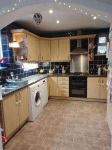 a kitchen with a washing machine and a washer at Beautiful family home in Taffs Well