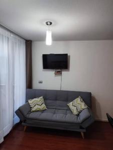 a living room with a couch and a flat screen tv at Departamento en centro de Viña del Mar in Viña del Mar