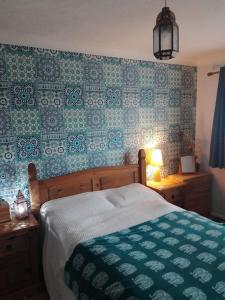 a bedroom with a bed with a green and white quilt at Beautiful family home in Taffs Well