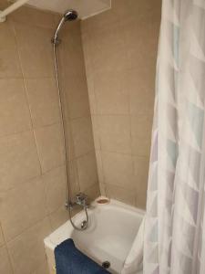 La salle de bains est pourvue d'une douche avec rideau de douche. dans l'établissement Departamento en centro de Viña del Mar, à Viña del Mar