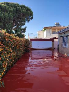 a pool of red water in a yard with flowers at Chalet Matalascañas in Matalascañas