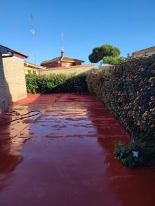 un ruisseau d'eau rouge assis sur un trottoir dans l'établissement Chalet Matalascañas, à Matalascañas