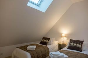 2 Betten in einem Dachzimmer mit Dachfenster in der Unterkunft Appartement Lamotte-Beuvron in Lamotte-Beuvron