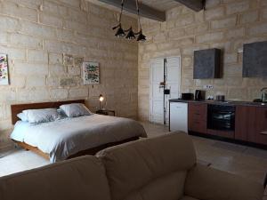 a bedroom with a bed and a couch and a kitchen at Beautiful Studio apartment in Qormi Malta in Qormi