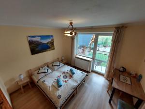 a small bedroom with a bed and a large window at Hostel & Apartments u Florka 2 in Zakopane