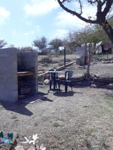 um pátio com uma mesa e cadeiras num quintal em Cabañas Dulce Atardecer em Villa Carlos Paz