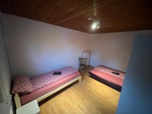 2 letti in una camera con pavimento in legno di Siegen Achenbach 2 a Siegen