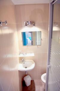 W łazience znajduje się umywalka, lustro i toaleta. w obiekcie Villa I Merli Nous contacter avant réservation w mieście Saint-Florent