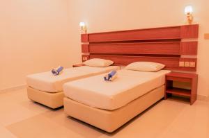 two beds sitting next to each other in a room at Feridhoo Inn in Feridhoo
