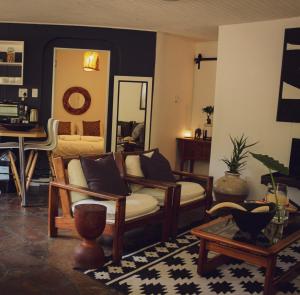 a living room with a couch and a mirror at ALLURING SELF CATERING 2 BEDROOM VILLA at BOKMAKIERIE VILLAS in Windhoek