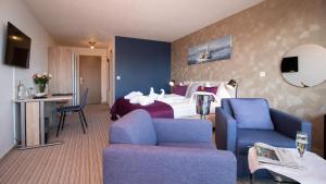 una camera d'albergo con letto e divano di Park - Hotel Inseli a Romanshorn