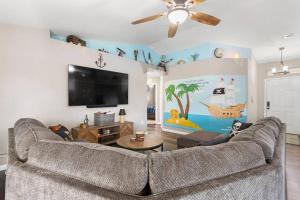 een woonkamer met een bank en een flatscreen-tv bij Cruz Family Treasure All In One Home in Navarre