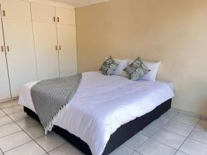 a bedroom with a bed with white sheets and pillows at Summerstrand holiday home in Summerstrand