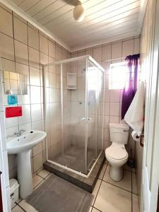 a bathroom with a shower and a toilet and a sink at Summerstrand holiday home in Summerstrand