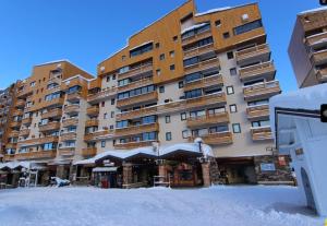 een groot gebouw met sneeuw ervoor bij Val Thorens, Centre Station, résidence Ski aux pieds, FREE WIFI, in Val Thorens