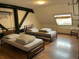 two twin beds in a room with a window at Familiehuis voor 13 personen in Diever