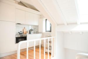een witte keuken met witte kasten en een trap bij Novo Apartamento Porto - Vistas Rio Douro in Porto