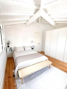 een witte slaapkamer met een groot bed en een houten vloer bij Novo Apartamento Porto - Vistas Rio Douro in Porto